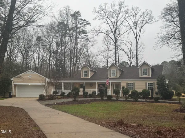 a front view of a house with a garden and trees