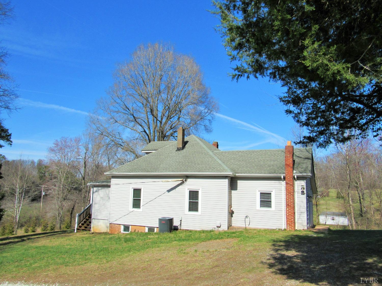 1697 South Amherst Highway Amherst, VA 24521 - Photo 5 of 45 a view of a white house next to a yard with large trees