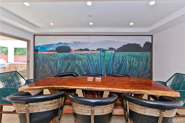 a dining room with furniture a rug and a floor to ceiling window