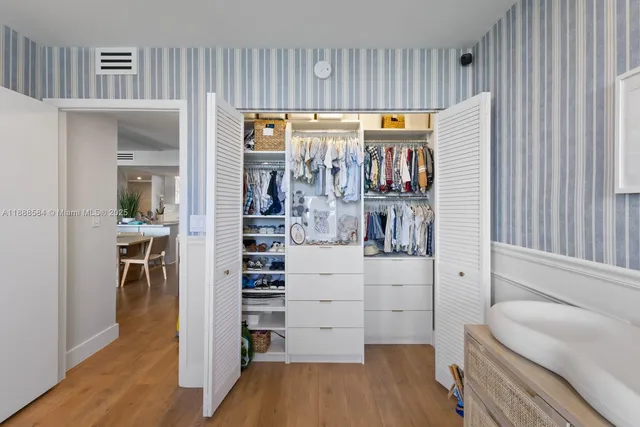 a view of walk in closet with wooden floor