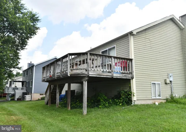 a view of house with a yard and deck