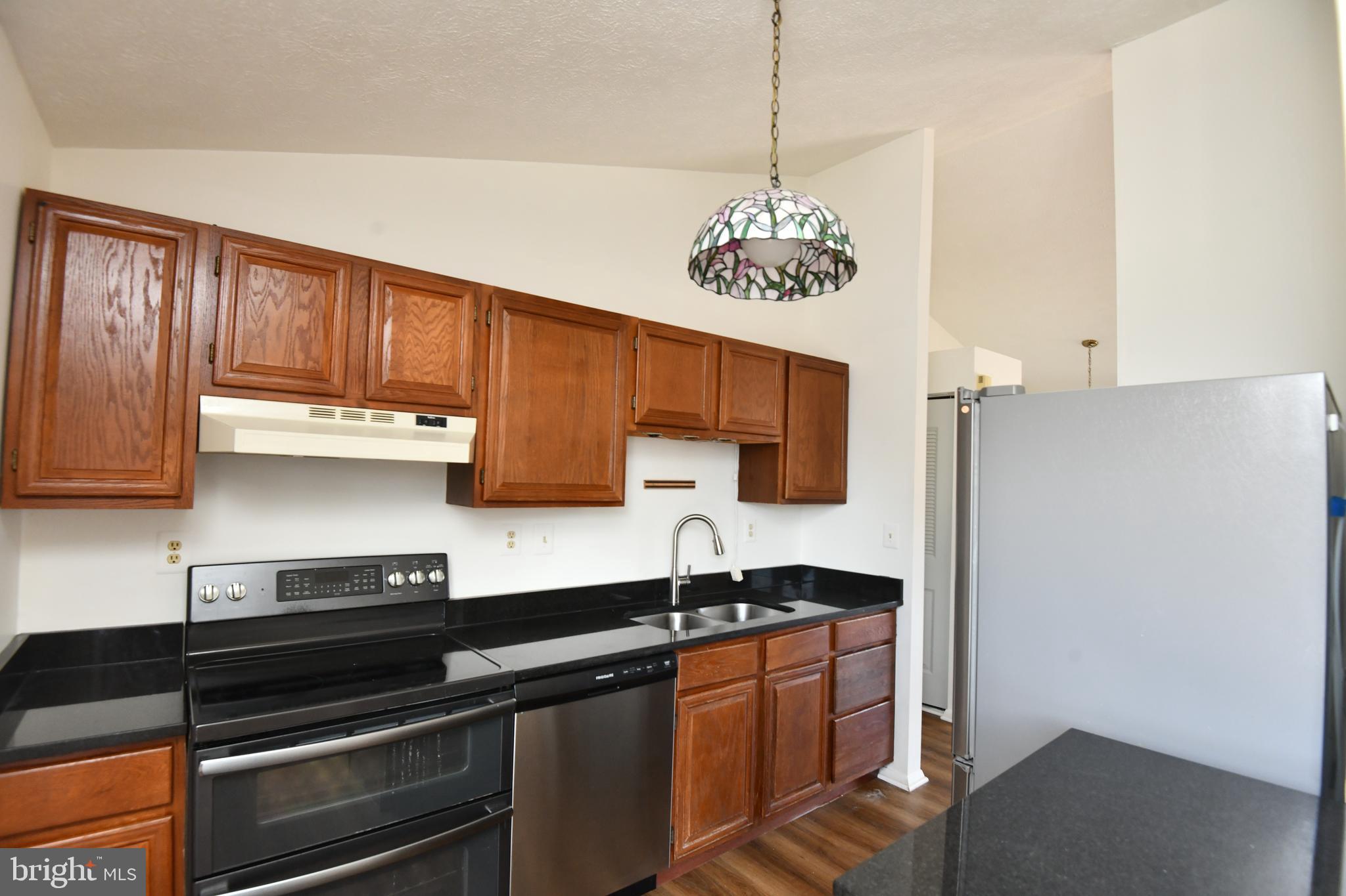 3863 Beech Down Drive Chantilly, VA 20151 - Photo 4 of 13 a kitchen with stainless steel appliances granite countertop a sink cabinets and wooden floor