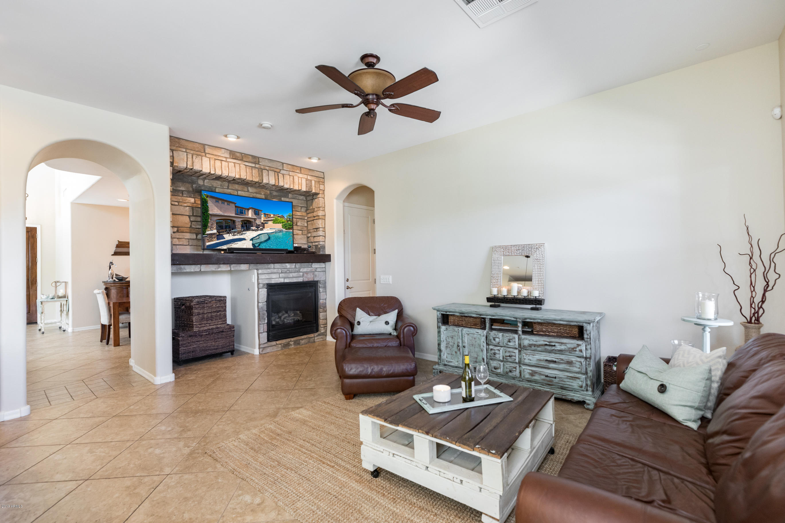 9185 East Canyon View Road Scottsdale, AZ 85255 - Photo 10 of 47 a living room with furniture a fireplace and a flat screen tv