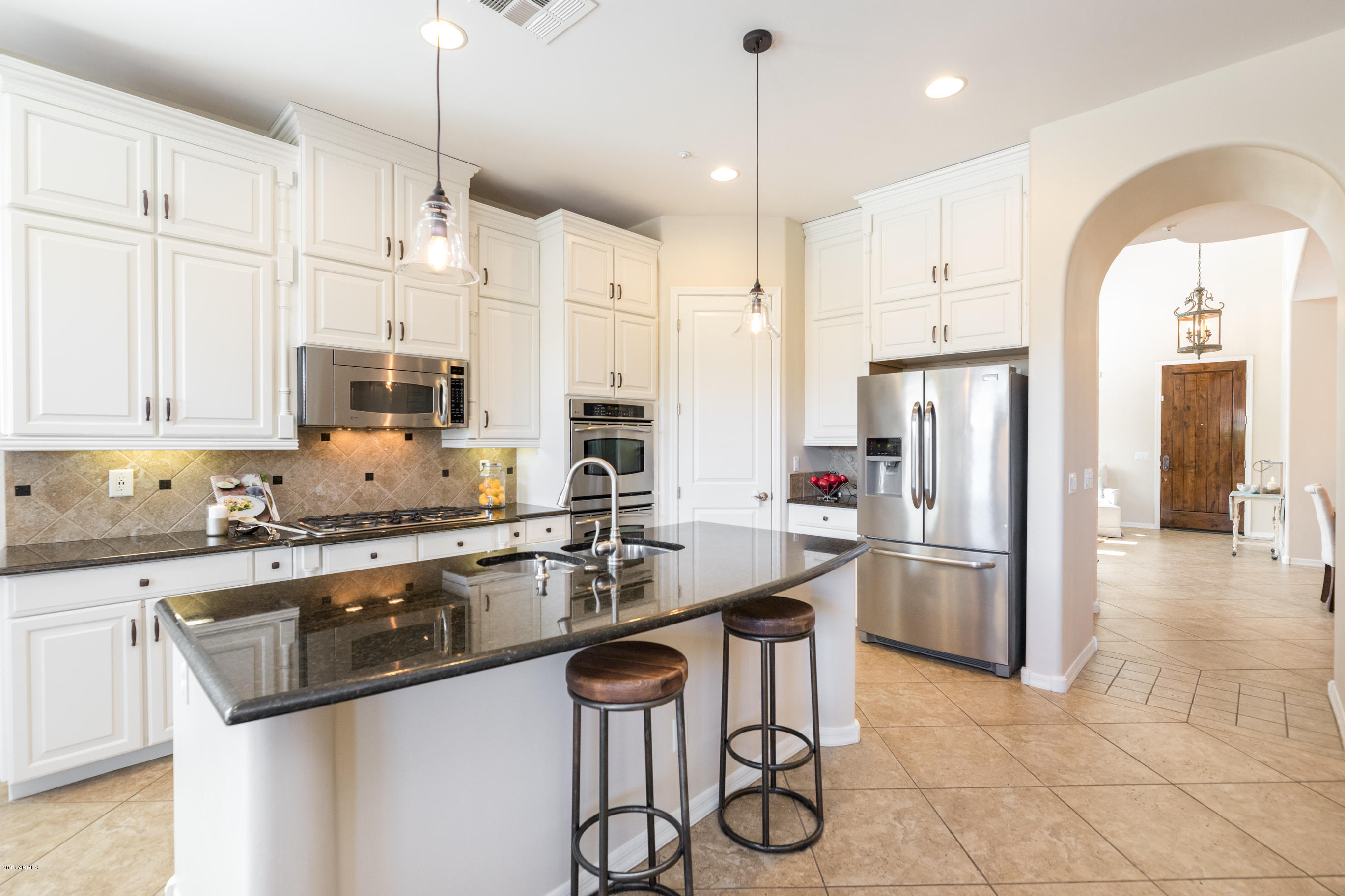9185 East Canyon View Road Scottsdale, AZ 85255 - Photo 16 of 47 a kitchen with stainless steel appliances granite countertop a refrigerator a sink a stove and white cabinets