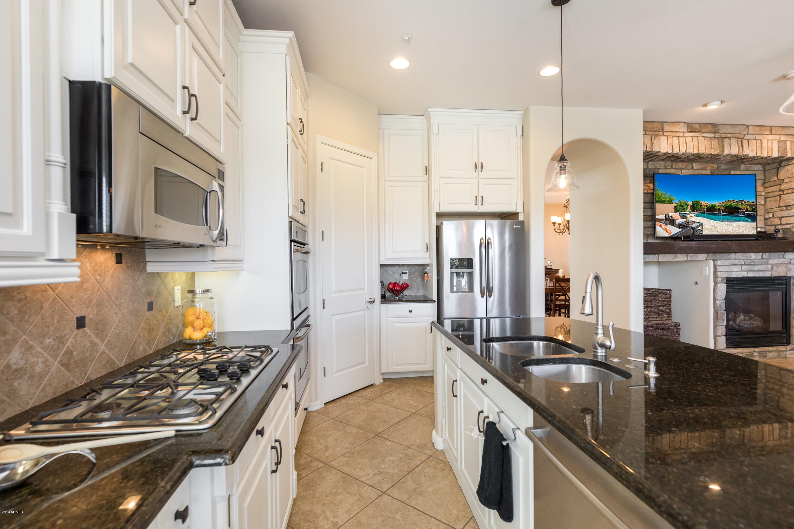 9185 East Canyon View Road Scottsdale, AZ 85255 - Photo 17 of 47 a kitchen with stainless steel appliances granite countertop a sink stove and refrigerator