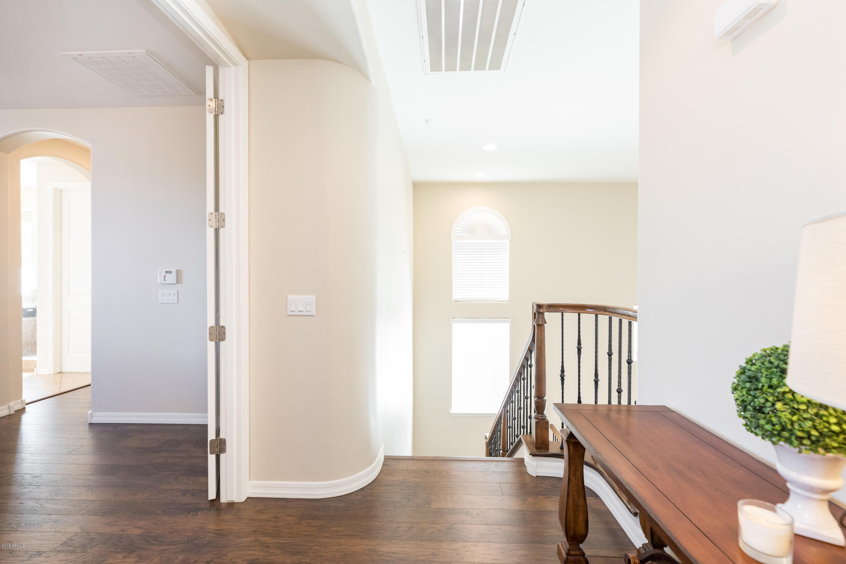 9185 East Canyon View Road Scottsdale, AZ 85255 - Photo 20 of 47 a view of a hallway with wooden floor and staircase