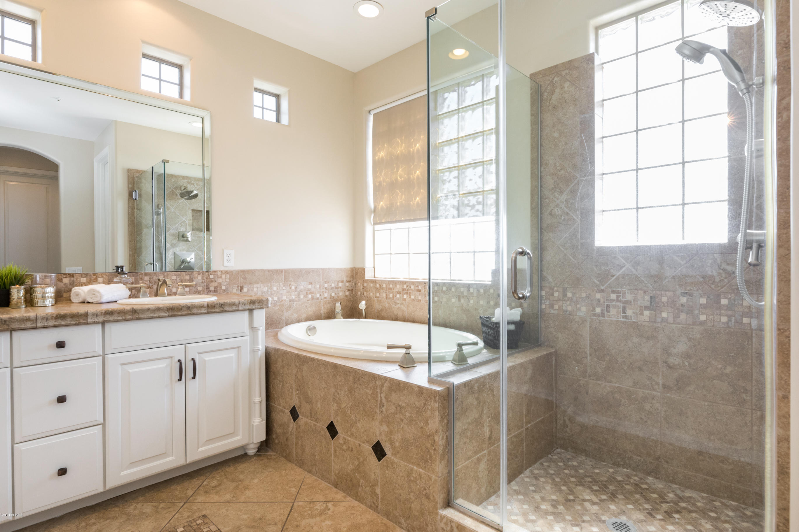 9185 East Canyon View Road Scottsdale, AZ 85255 - Photo 25 of 47 a bathroom with a double vanity sink a large mirror and a bathtub