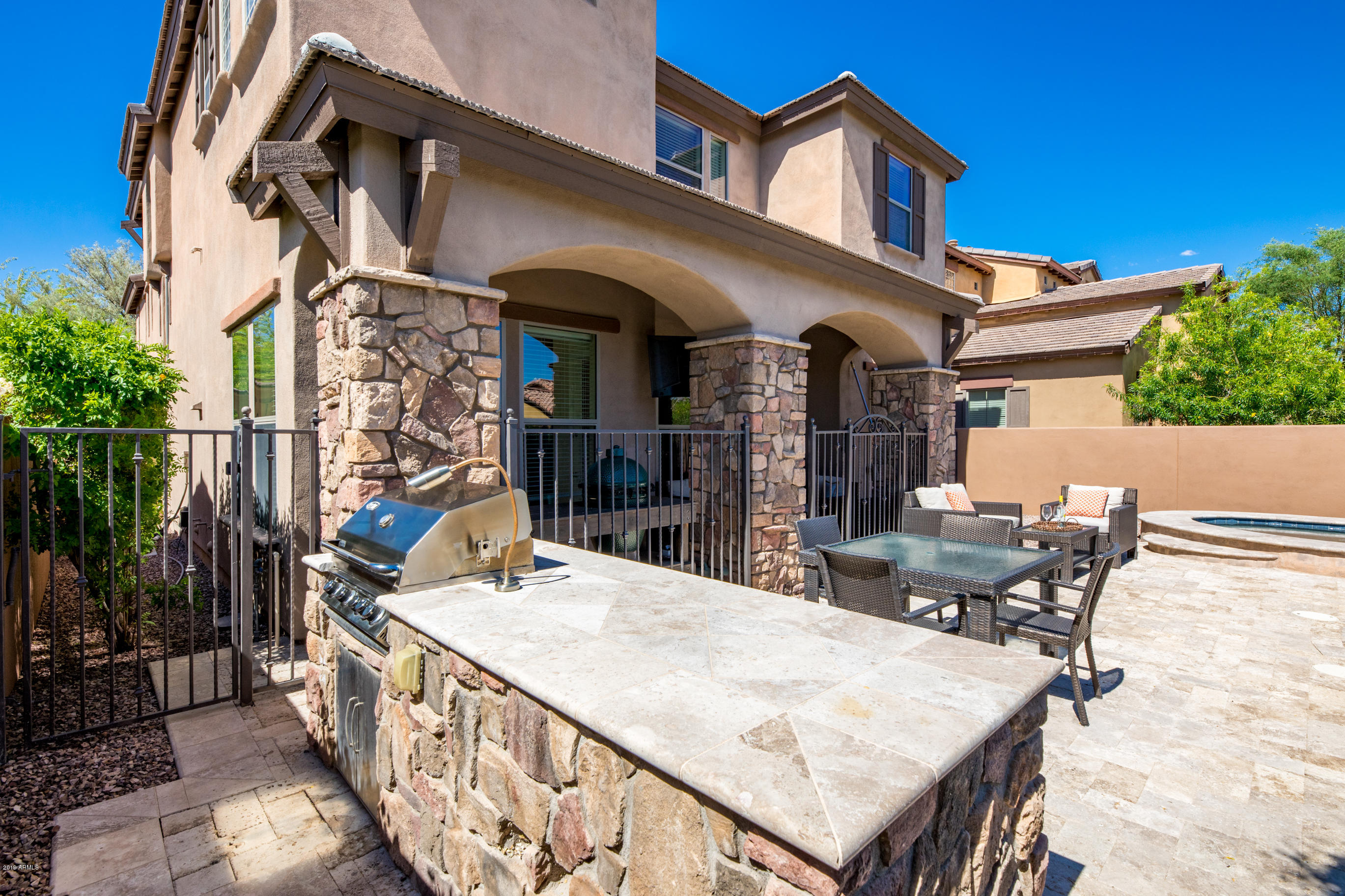 9185 East Canyon View Road Scottsdale, AZ 85255 - Photo 36 of 47 front view of a house with a chairs and table in the patio