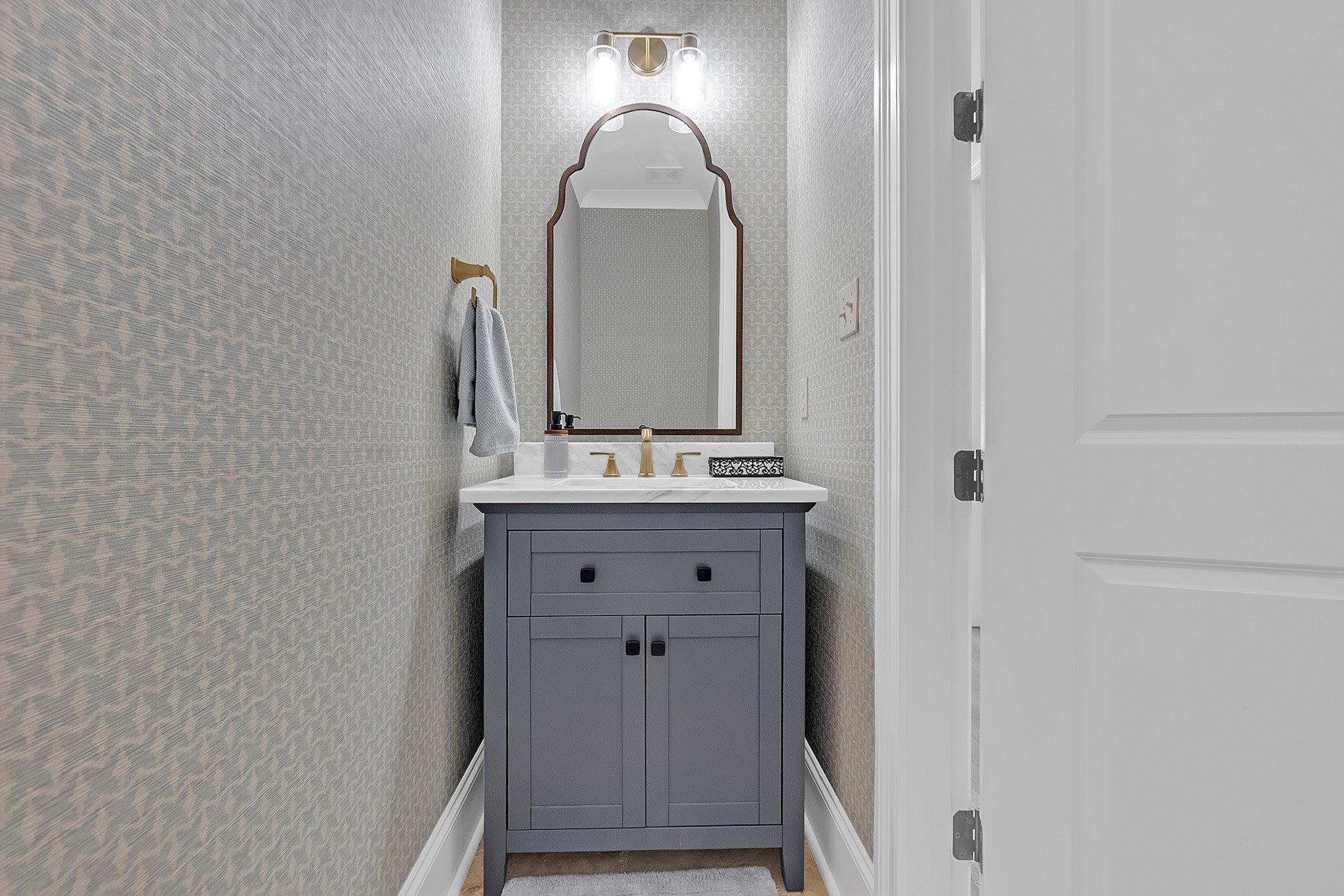 3246 North Hartwell Ridge Drive Collierville, TN 38017 - Photo 10 of 40 Powder room featuring a gray shaker-style vanity with storage cabinetry, white countertop, and gold-tone faucet