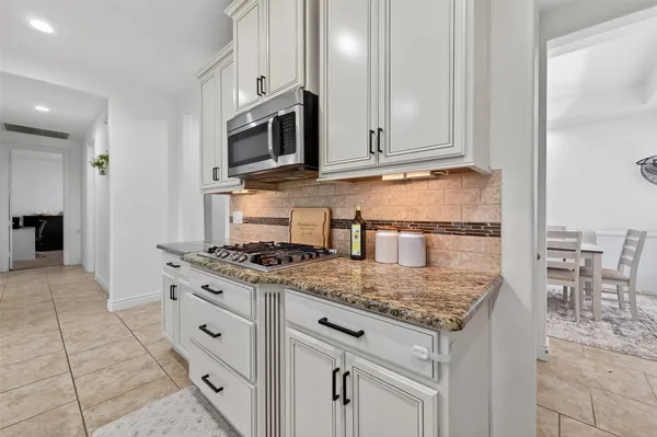 a kitchen with stainless steel appliances granite countertop a stove and a microwave