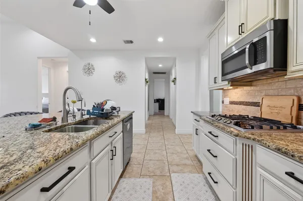 a kitchen with stainless steel appliances granite countertop a sink stove and cabinets