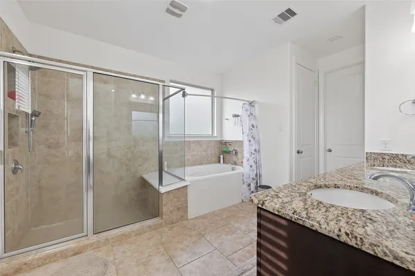 a bathroom with a granite countertop sink a toilet and shower