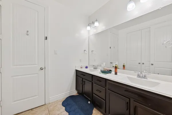 a bathroom with double vanity sink and a mirror
