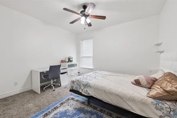 a bedroom with a bed a desk and chair