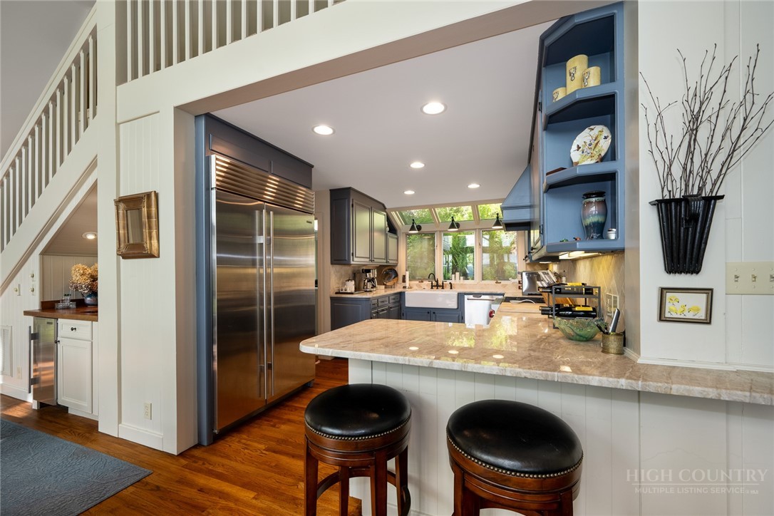 246 Mulberry Lane Boone, NC 28607 - Photo 25 of 49 a kitchen with stainless steel appliances granite countertop a refrigerator a stove and a sink with wooden floor
