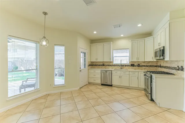 a kitchen with a stove sink and cabinets