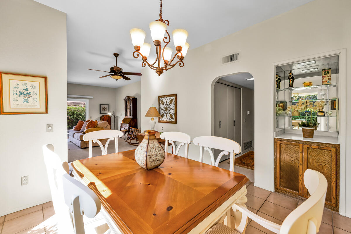 44149 Chamonix Court Palm Desert, CA 92260 - Photo 12 of 50 a view of a dining room with furniture a chandelier and wooden floor