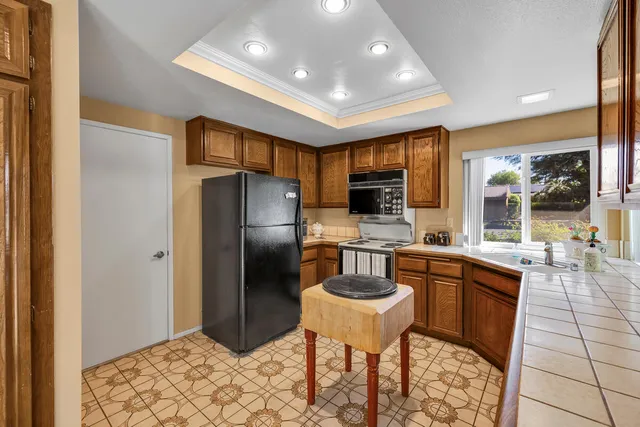 a kitchen that has a sink and chairs in it