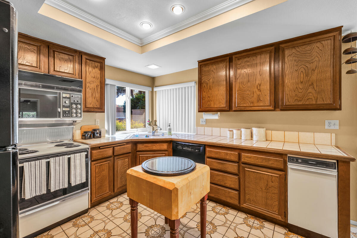 44149 Chamonix Court Palm Desert, CA 92260 - Photo 15 of 50 a kitchen that has a sink and chairs in it