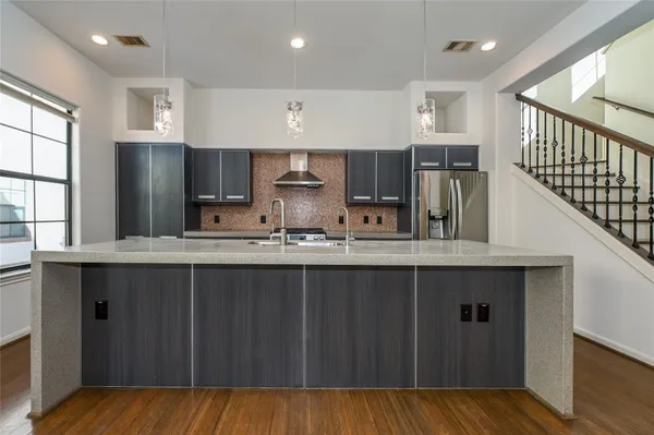 a kitchen with stainless steel appliances a sink cabinets and wooden floor