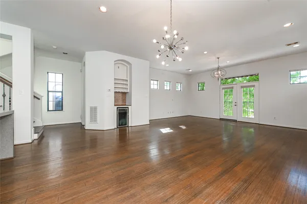 an empty room with wooden floor and large windows