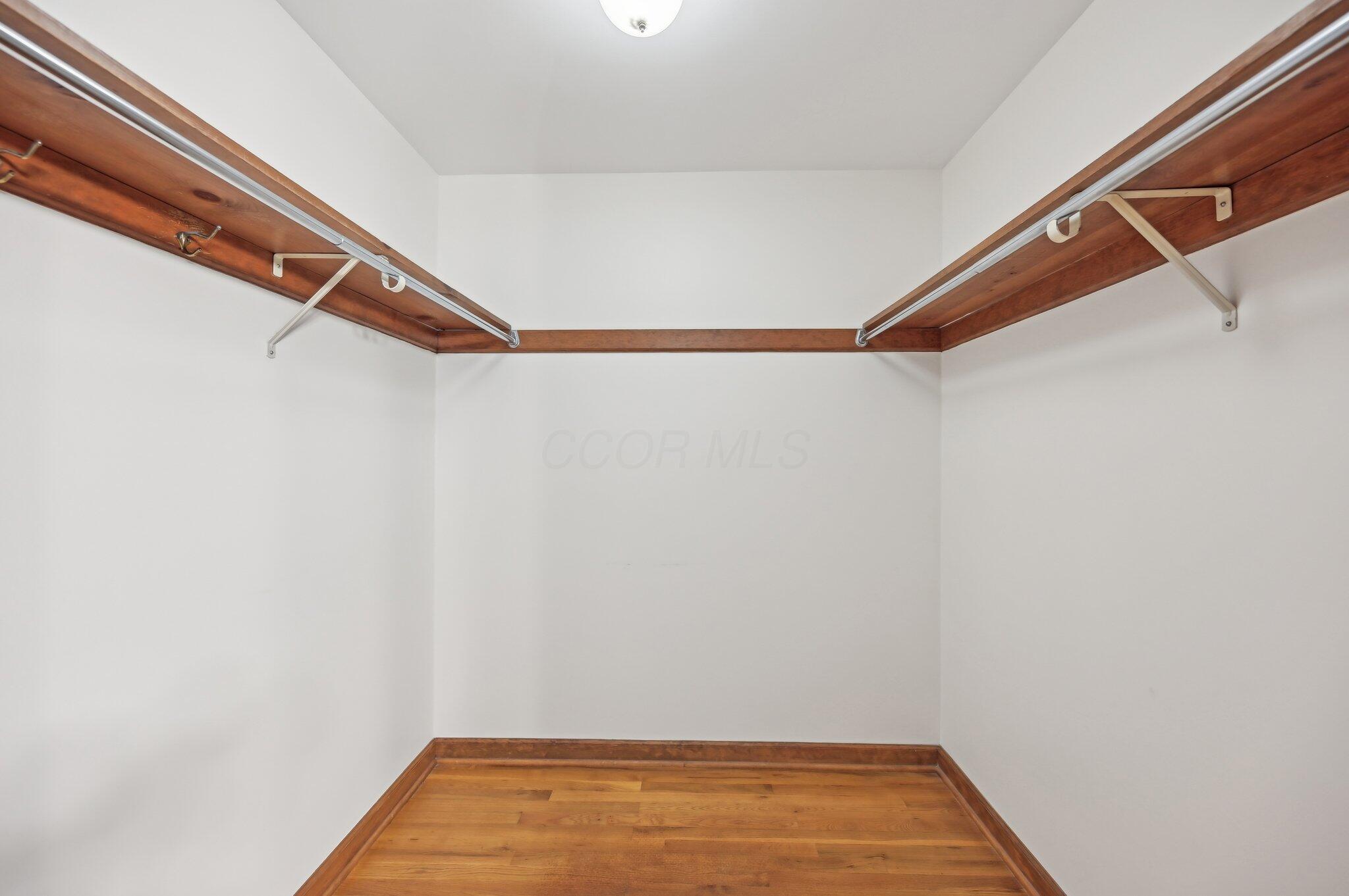 5917 Rocky Rill Road Columbus, OH 43235 - Photo 28 of 47 Walk-in closet with dual hanging rods and wood trim, offering ample storage space.