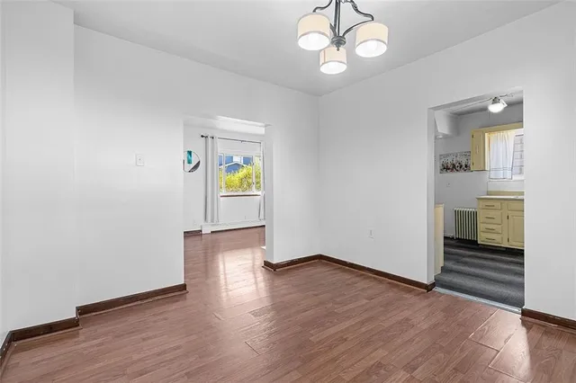 an empty room with wooden floor and window