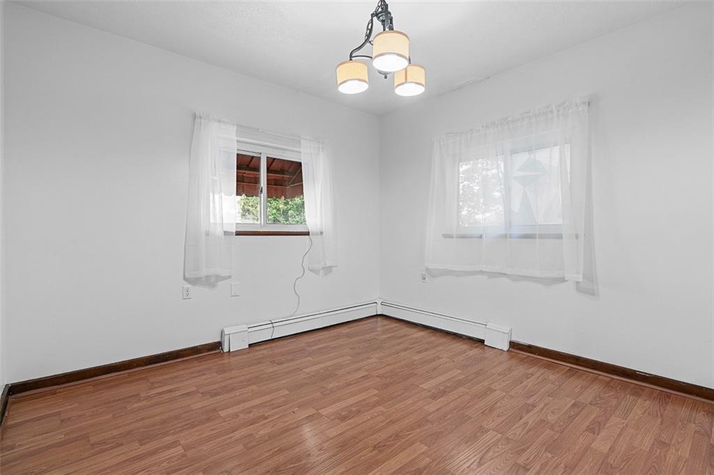 404 1/2 Franklin Avenue Vandergrift, PA 15690 - Photo 8 of 31 an empty room with wooden floor exposed radiator and windows