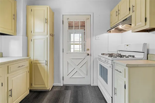 a kitchen with white cabinets and white appliances