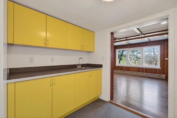 a room with a black white checkered floor with a gaming machine and wooden floor