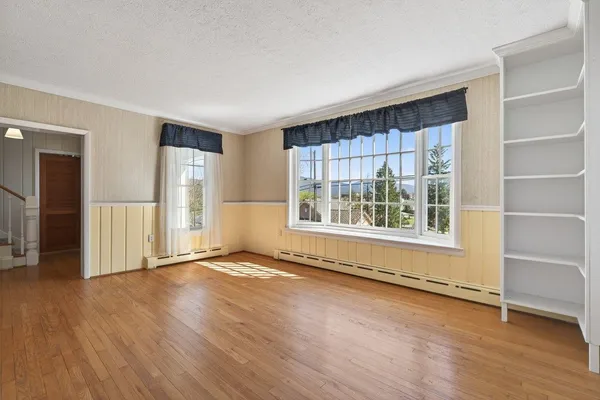 a view of an empty room with wooden floor