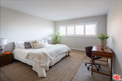 a bedroom with a bed and a potted plant