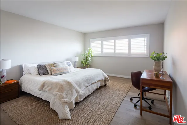 a bedroom with a bed and a potted plant
