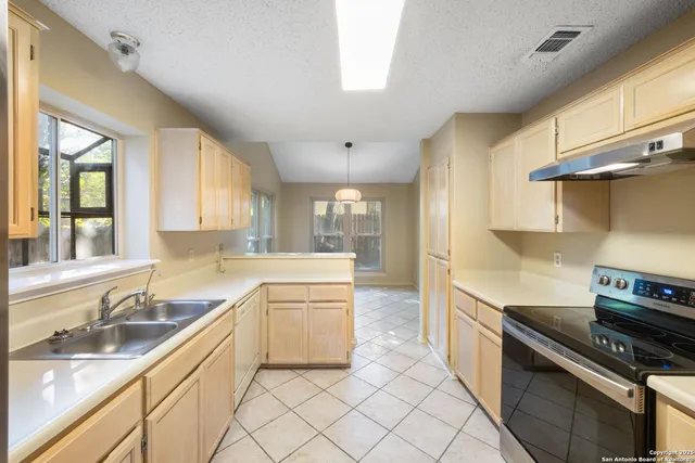 a kitchen with granite countertop a sink stainless steel appliances and cabinets