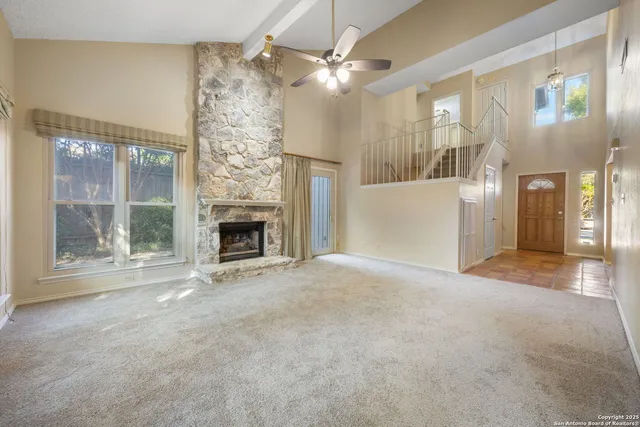 a view of an empty room with a fireplace and a window