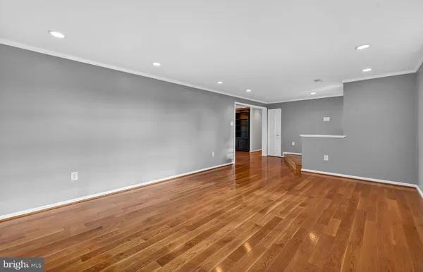 a view of an empty room with wooden floor
