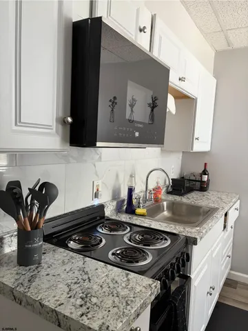 a kitchen with granite countertop a stove and a sink