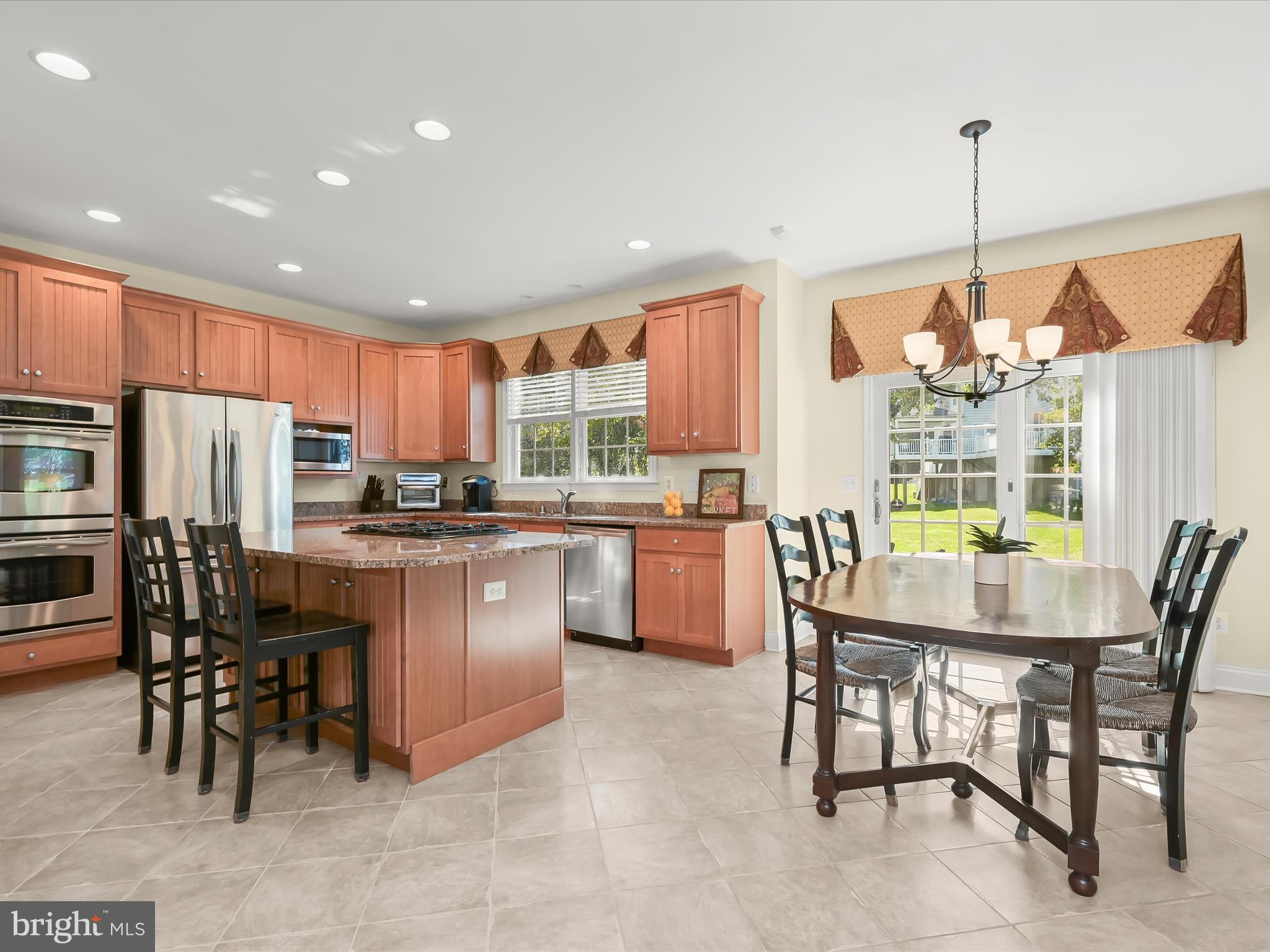 1525 Winfields Lane Gambrills, MD 21054 - Photo 19 of 65 a kitchen with stainless steel appliances granite countertop a table chairs refrigerator and a sink