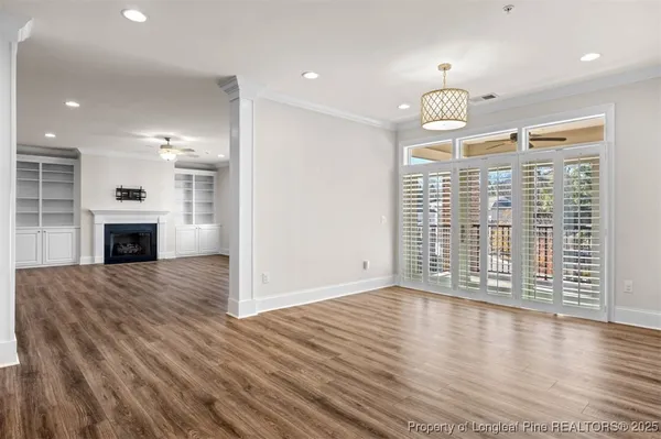 a view of empty room with wooden floor and fireplace
