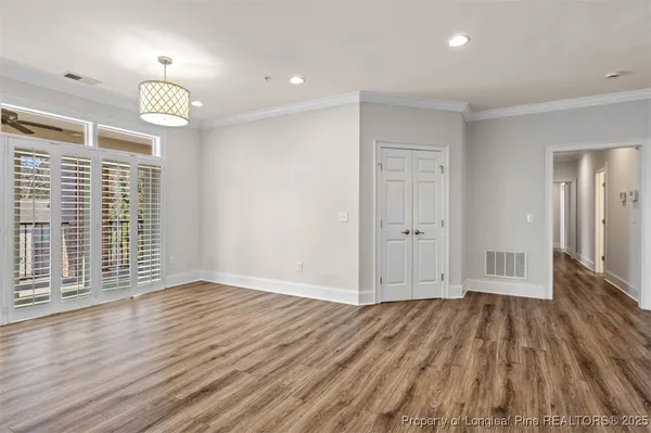 a view of empty room with wooden floor