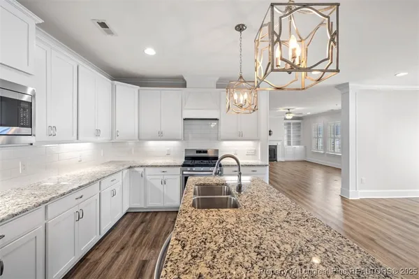 a kitchen with a sink a stove and cabinets
