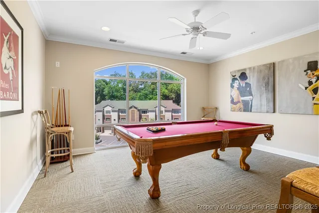 a room with furniture pool table and windows