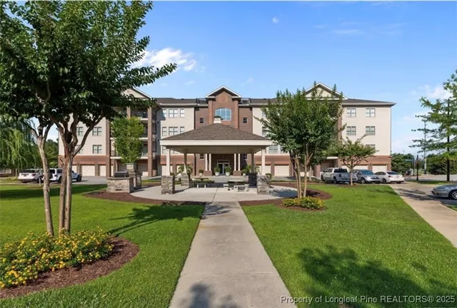 a front view of a house with garden and trees