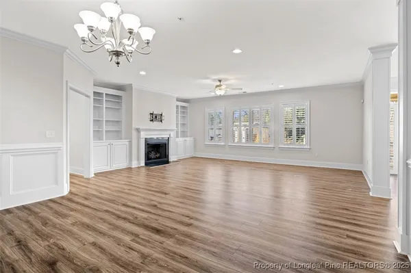 a view of a livingroom with wooden floor and a ceiling fan