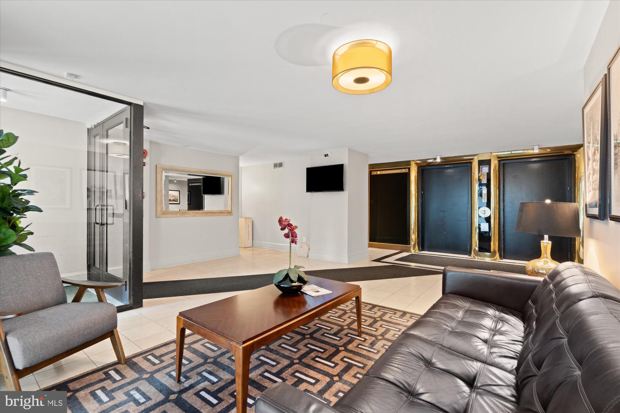 1245 13th Street Northwest, Unit 508 Washington, DC 20005 - Photo 13 of 15 a living room with a couch and a potted plant