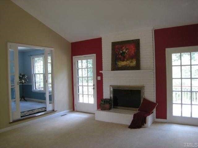 5208 Badham Place Raleigh, NC 27609 - Photo 7 of 12 an empty room with windows fireplace and fans