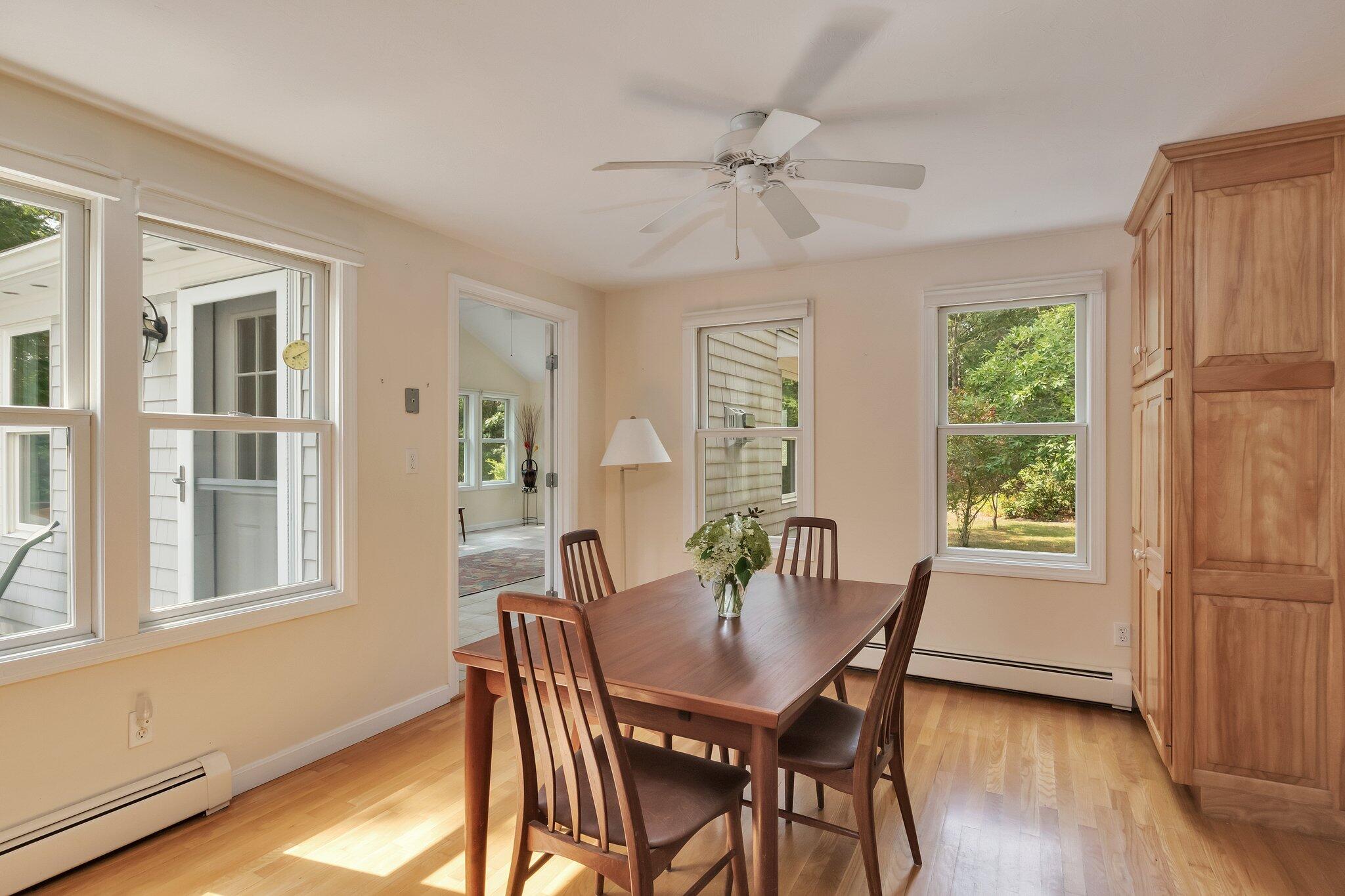 565 Sampsons Mill Road Cotuit, MA 02635 - Photo 16 of 87 a view of a dining room with furniture window and wooden floor