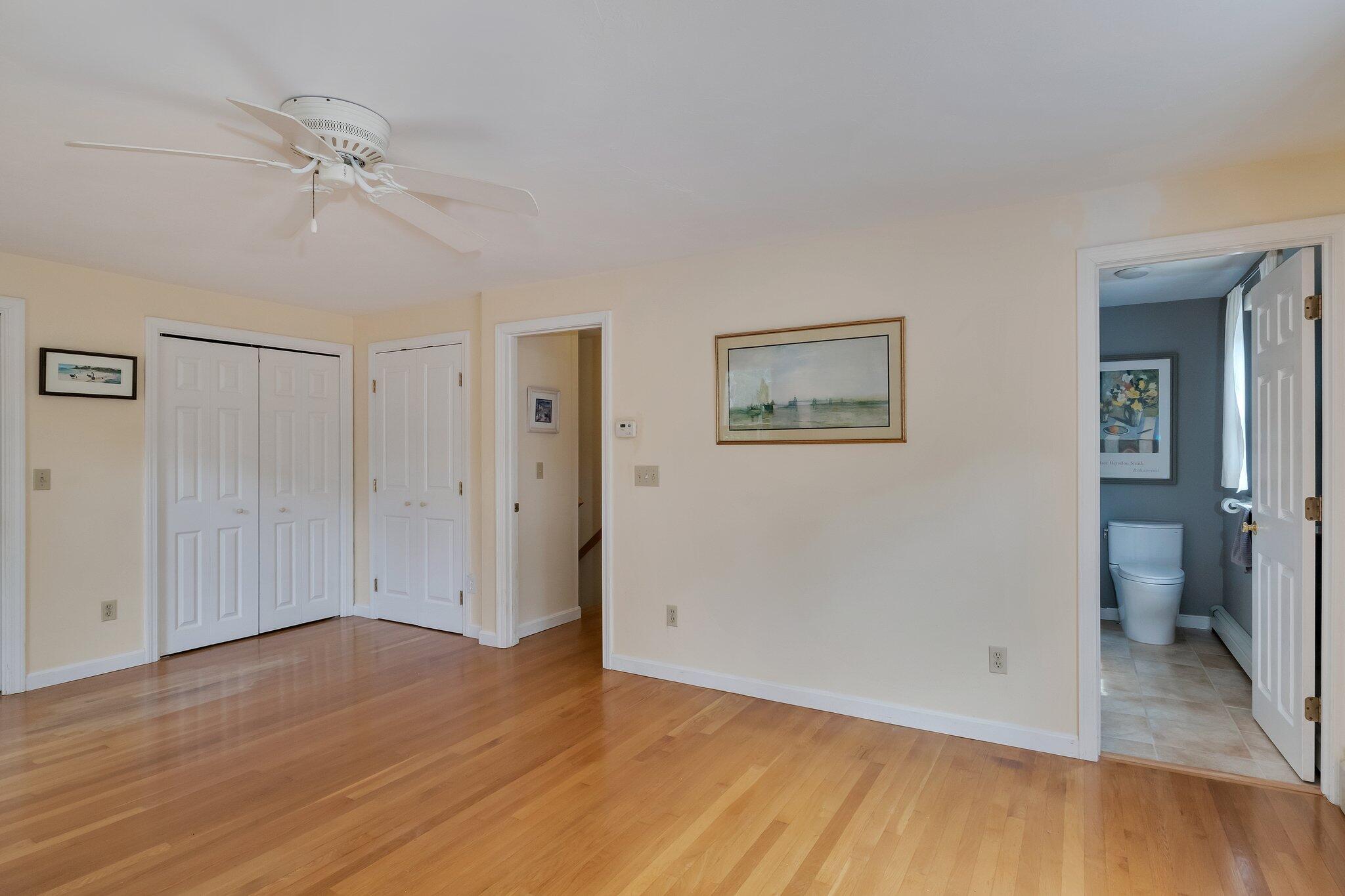 565 Sampsons Mill Road Cotuit, MA 02635 - Photo 44 of 87 an empty room with wooden floor and a ceiling fan