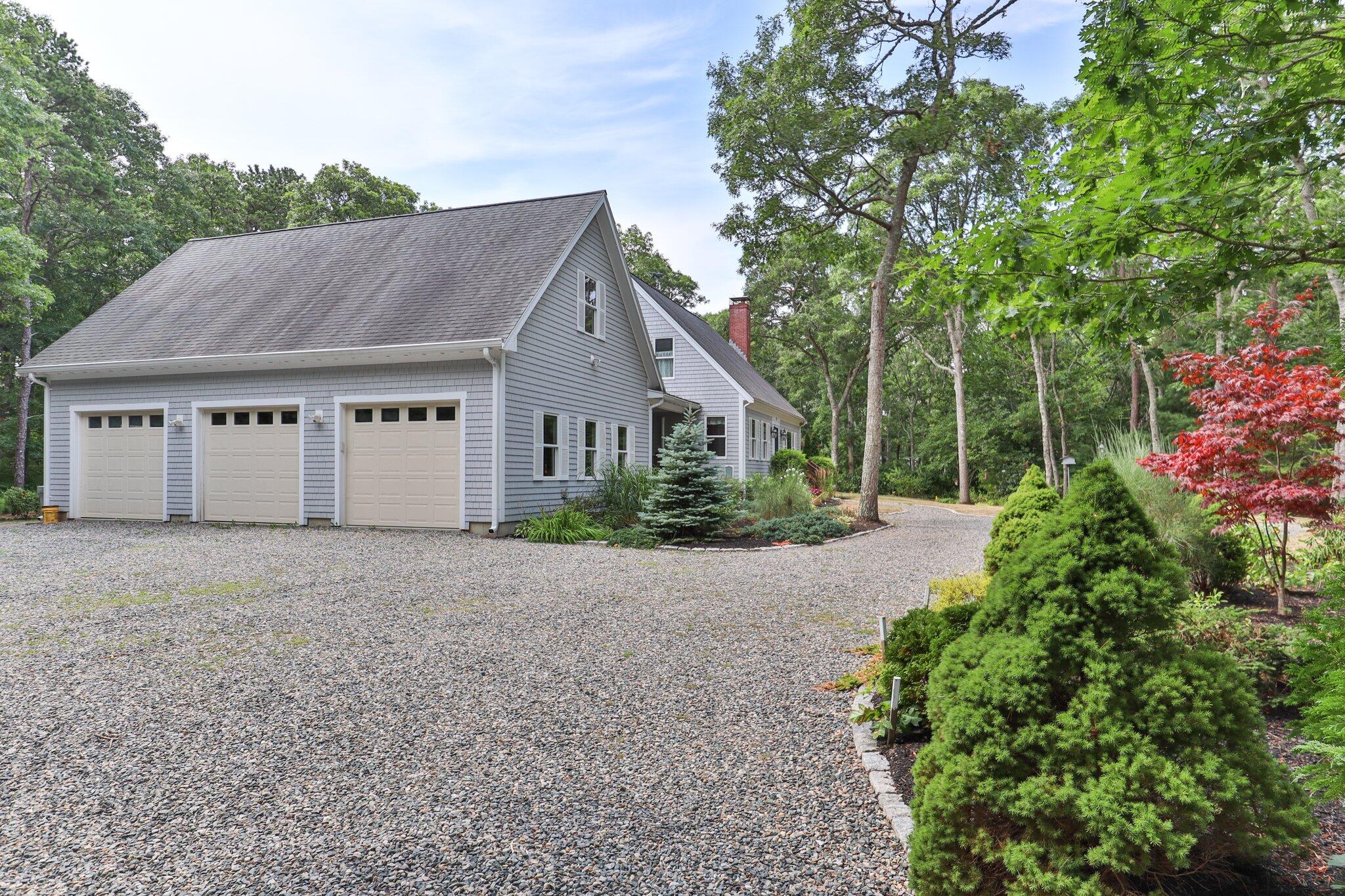 565 Sampsons Mill Road Cotuit, MA 02635 - Photo 74 of 87 a front view of a house with a garden and trees