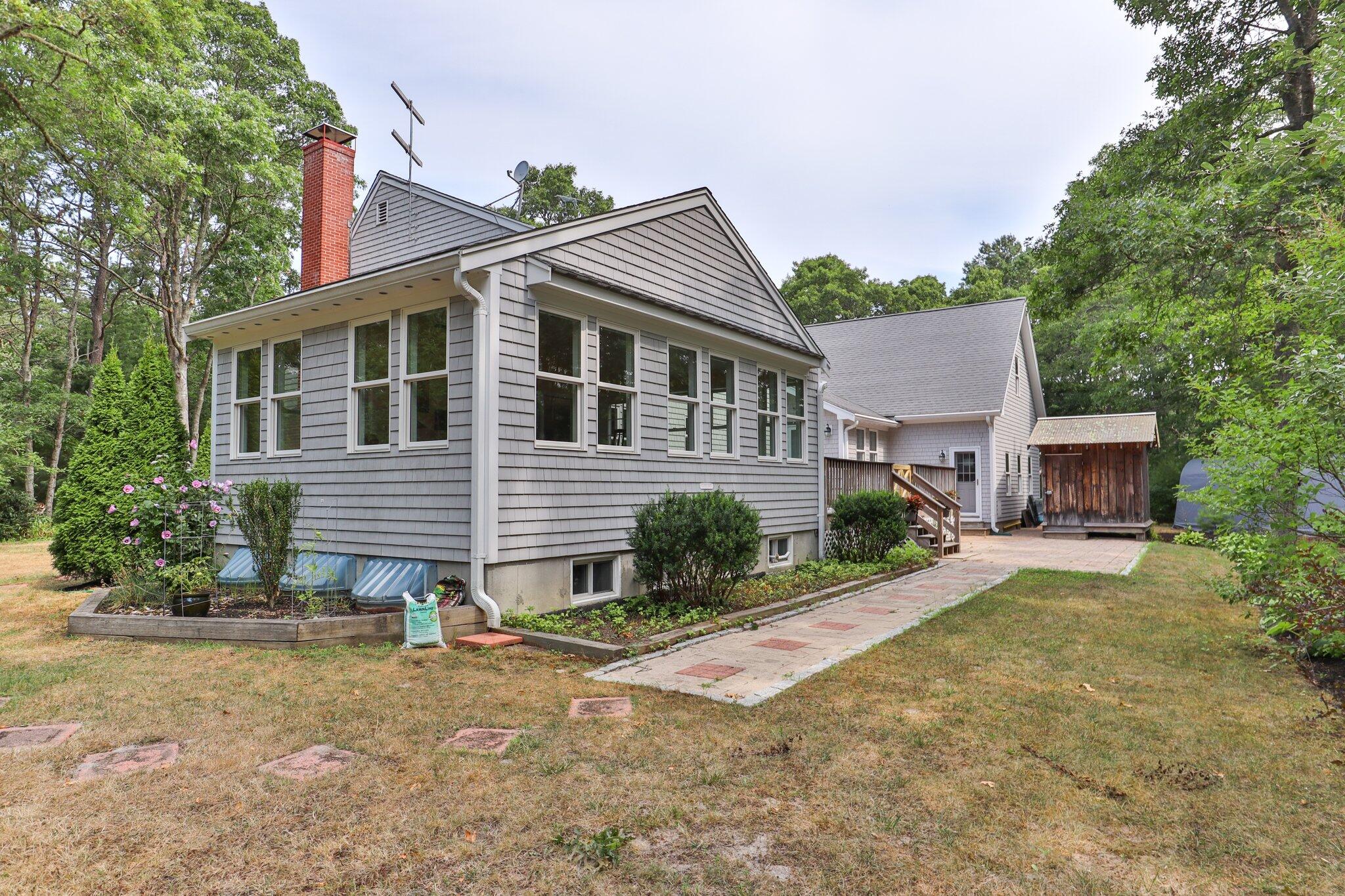565 Sampsons Mill Road Cotuit, MA 02635 - Photo 77 of 87 a view of a house with a yard and potted plants